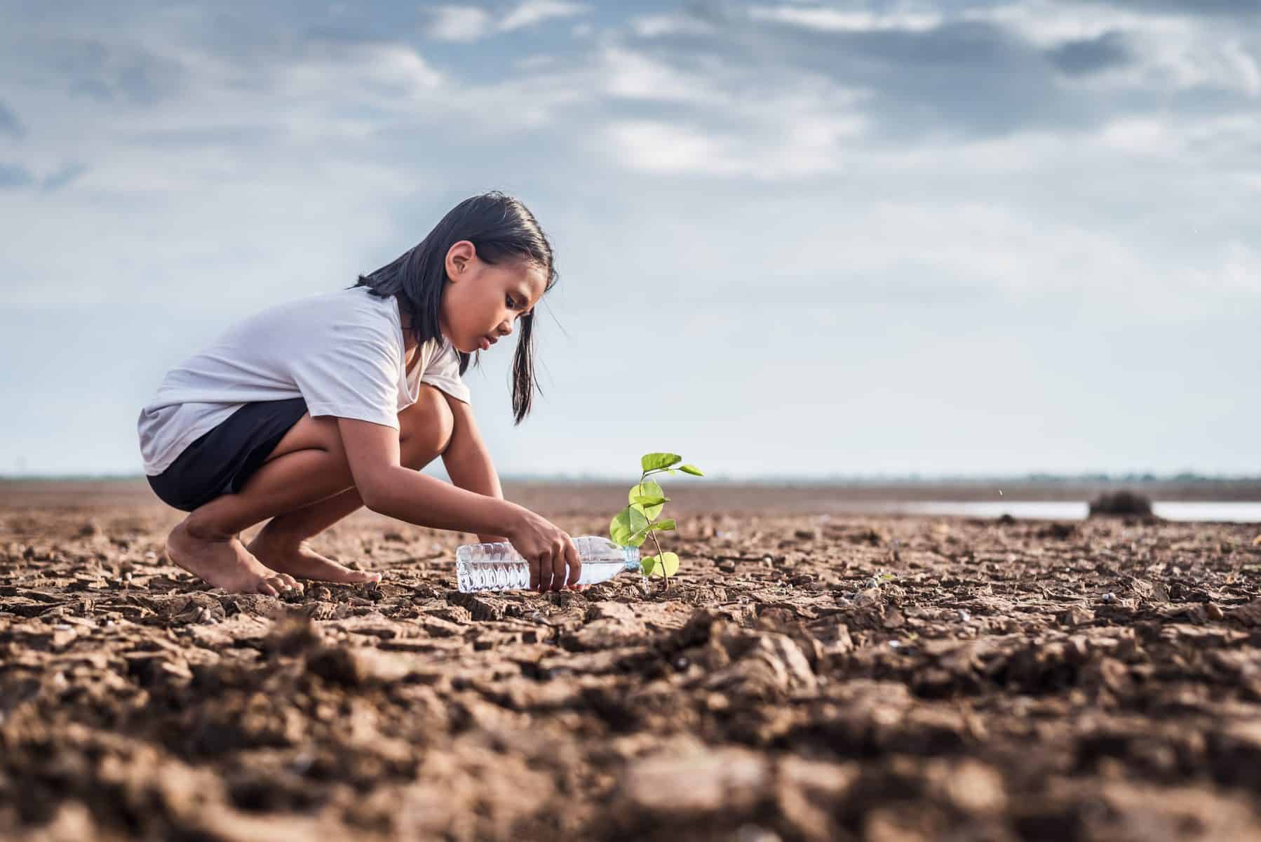 Young girl watering plant