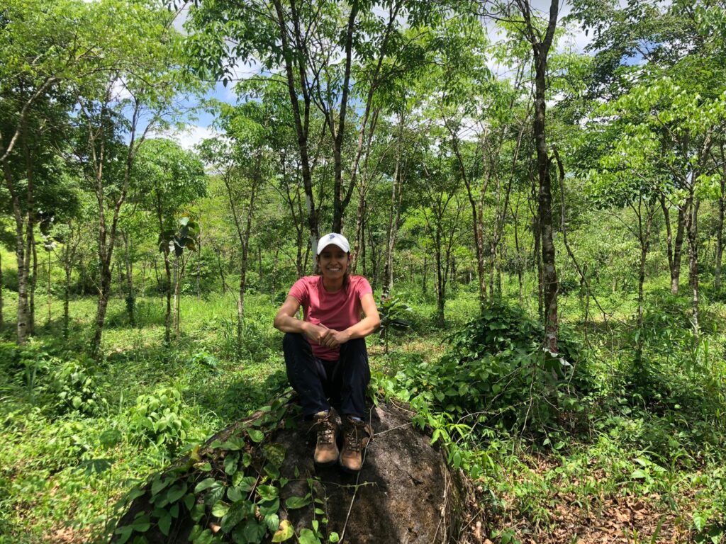 Lina Avila our Manager Natural Climate Solution sitting in the green forest.