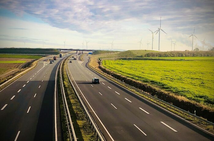 Autobahn through green landscape, wind mills in background