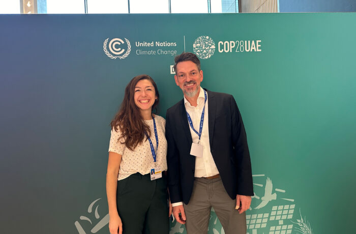 Astrid Manciu and Dirk Walterspacher infront of COP 28 photowall
